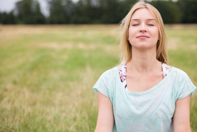Young woman with closed eyes experiencing harmony with nature